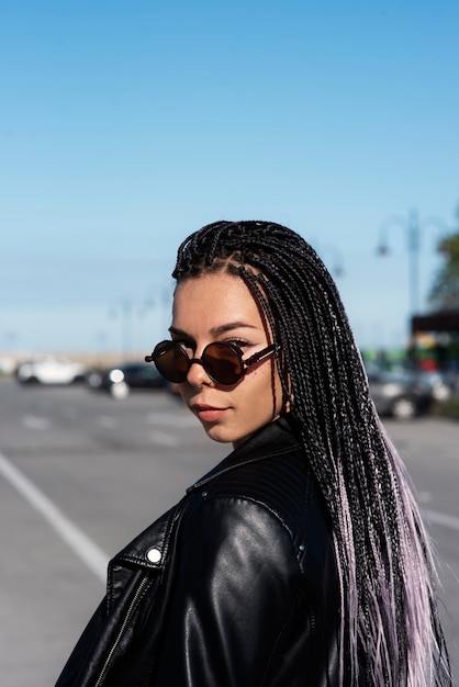 Photo gratuite vue latérale femme posant avec des lunettes de soleil