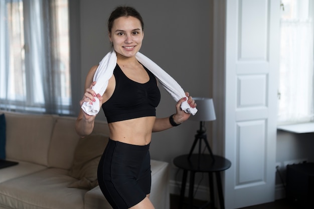 Vue latérale d'une femme posant avec une serviette et souriant