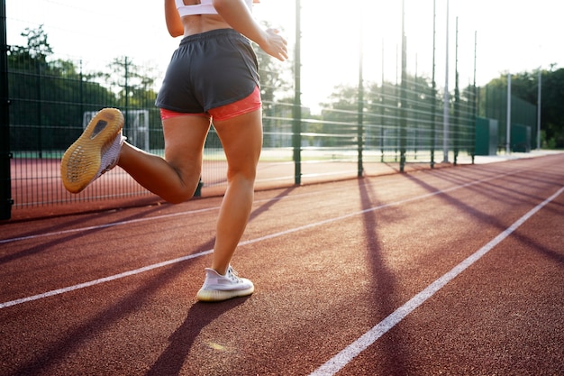 Vue latérale femme qui court sur la piste