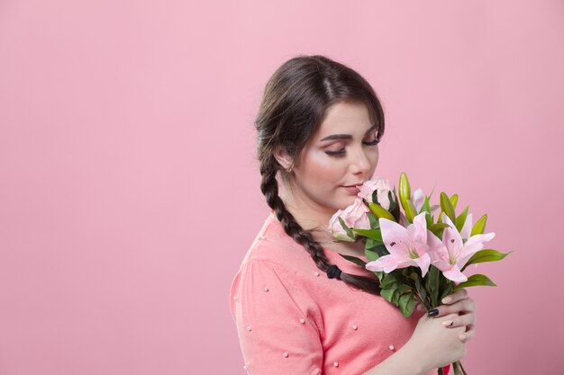 Vue latérale d'une femme qui sent le bouquet de Lys avec copie espace