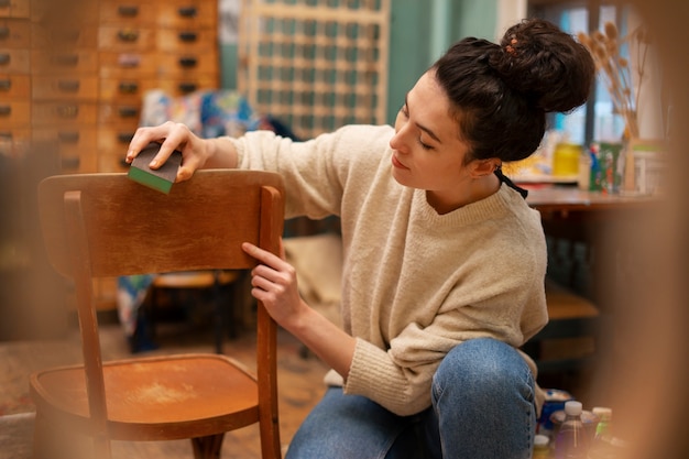 Vue latérale femme restaurant une chaise en bois