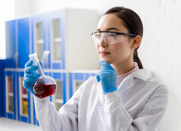 Vue latérale d'une femme scientifique regardant la substance et la pensée