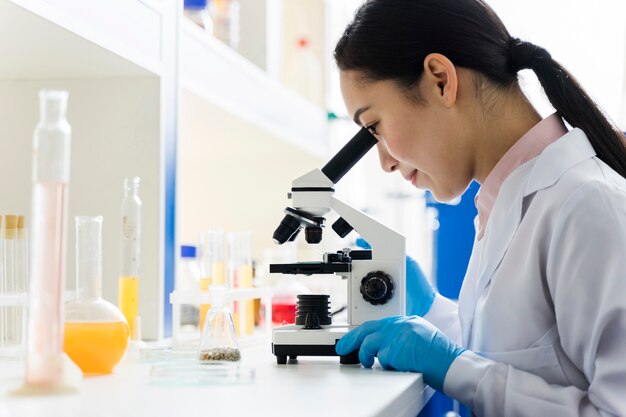 Vue latérale d'une femme scientifique travaillant dans le laboratoire