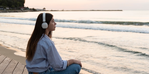 Vue latérale femme se détendre sur la plage avec espace copie