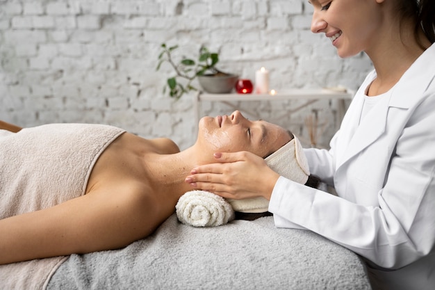 Vue latérale femme se faire masser au spa