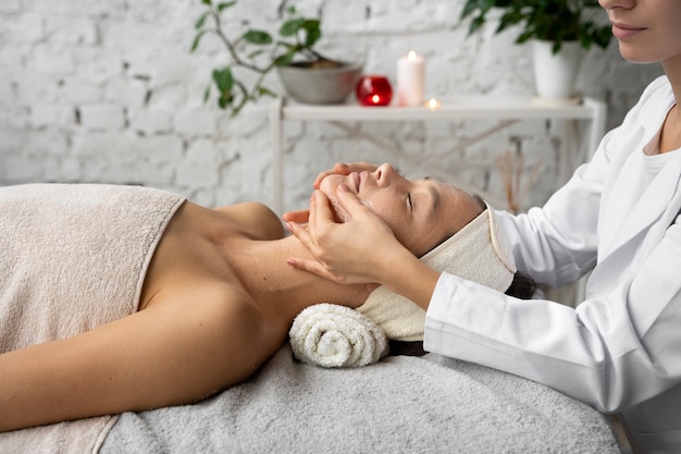 Photo gratuite vue latérale femme se faire masser au spa