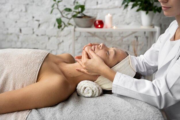 Vue latérale femme se faire masser au spa