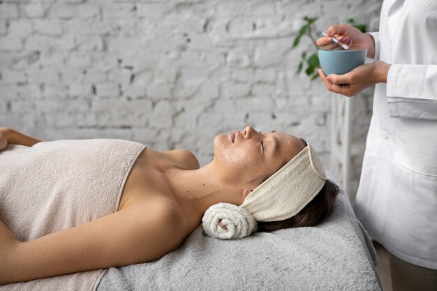 Vue latérale femme se faire masser au spa