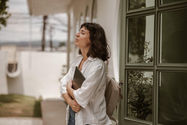 Vue latérale d'une femme séjournant avec un ordinateur portable