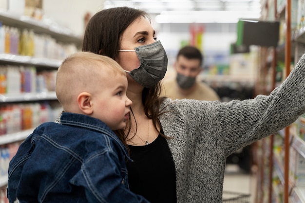 Photo gratuite vue latérale femme shopping avec enfant