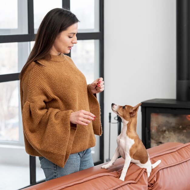 Vue latérale d'une femme avec son chien sur le canapé