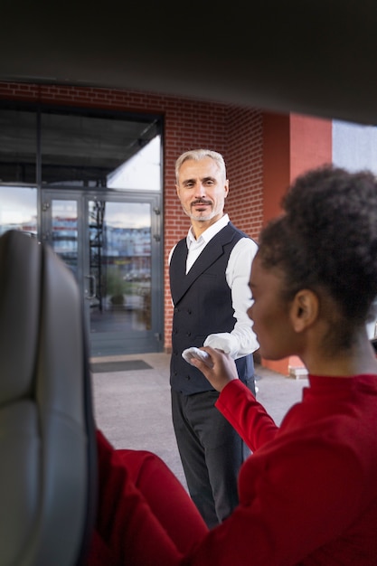 Photo gratuite vue latérale femme sortant de la voiture