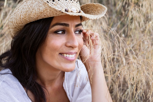 Vue latérale d'une femme souriante posant dans la nature