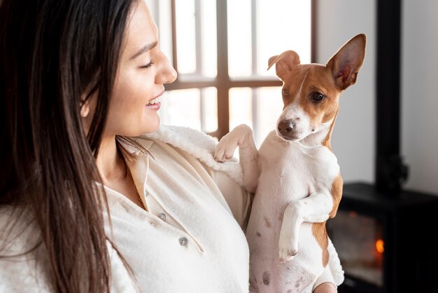 Vue latérale d'une femme souriante posant avec son chien