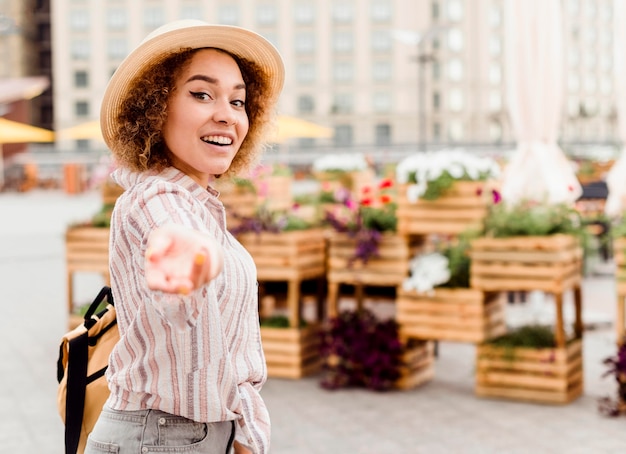 Photo gratuite vue latérale d'une femme souriante la tenant à côté d'elle