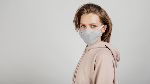 Photo gratuite vue latérale femme en sweat à capuche avec masque