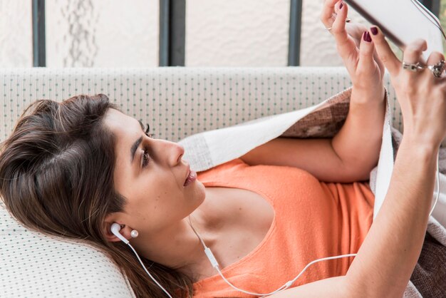 Vue latérale femme avec tablette et casque