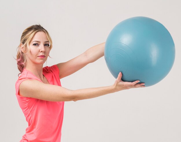 Vue latérale d'une femme tenant un ballon d'exercice