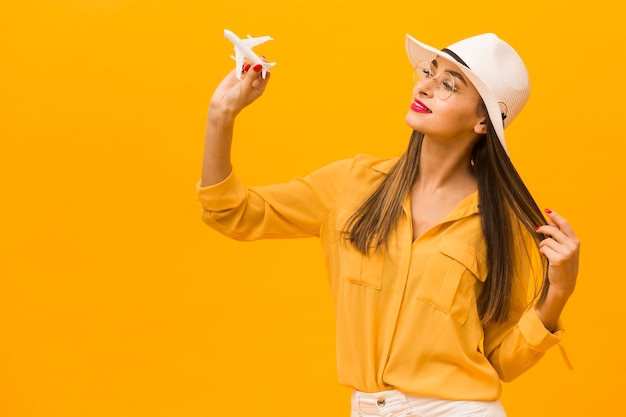 Vue latérale d'une femme tenant une figurine d'avion avec copie espace