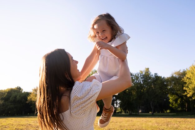 Vue latérale femme tenant une fille souriante