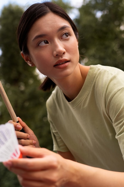 Vue latérale femme tenant une raquette de badminton