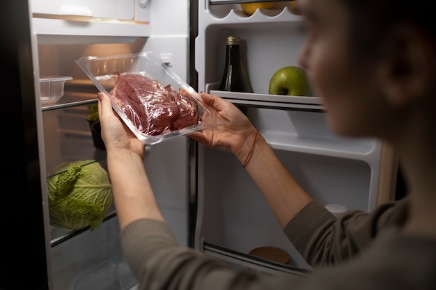 Vue latérale femme tenant de la viande