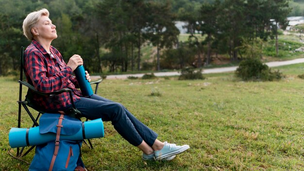 Vue latérale d'une femme touriste âgée prenant une pause à l'extérieur