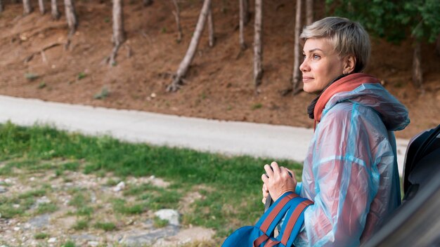 Vue latérale de la femme touristique senior dans la nature