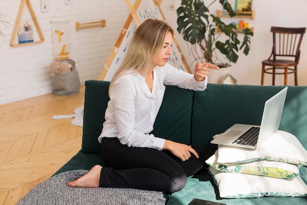 Vue latérale femme travaillant sur canapé