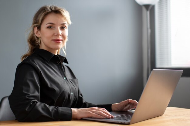 Vue latérale femme travaillant avec ordinateur portable