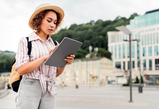 Vue latérale femme vérifiant sa tablette pour les directions