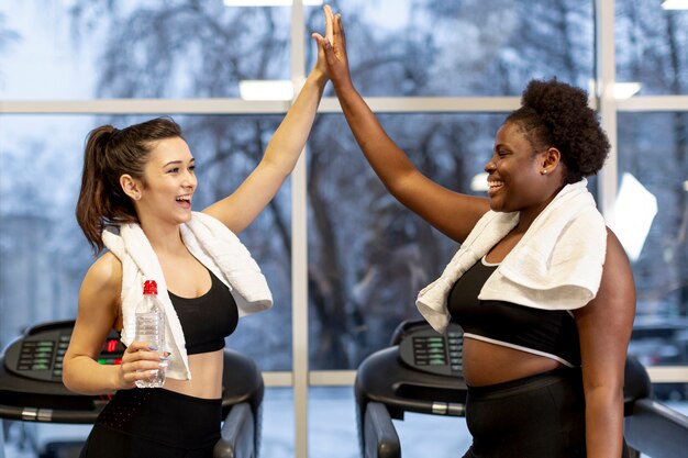 Vue latérale femmes au gymnase donnant cinq haut