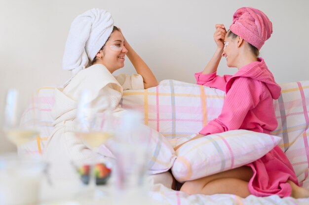 Vue latérale des femmes bénéficiant d'une journée de spa à la maison