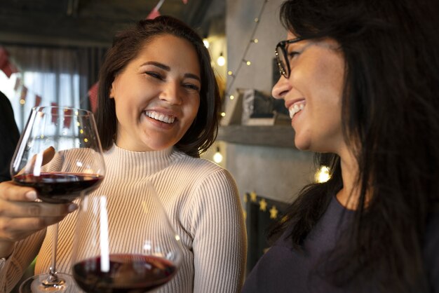 Vue latérale des femmes souriantes avec du vin