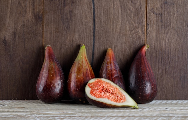 Vue latérale des figues de mission avec la moitié de figue sur une table en bois. horizontal