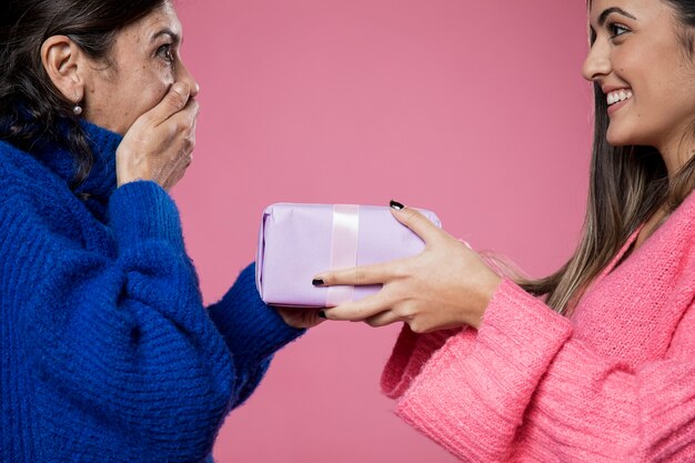 Vue latérale fille donnant un cadeau à maman