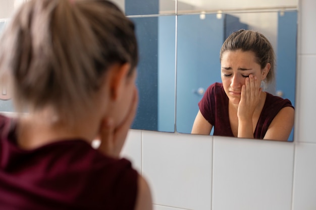 Vue latérale fille pleurant dans la salle de bain