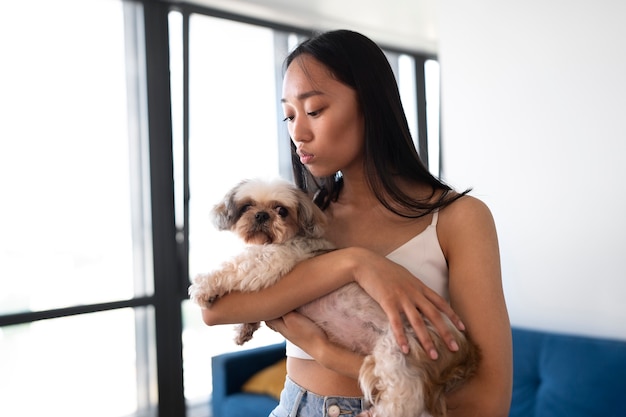 Vue latérale fille tenant un chien mignon