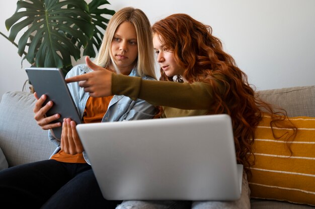 Photo gratuite vue latérale des filles critiquant la tablette