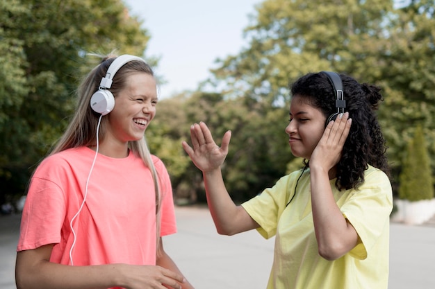 Photo gratuite vue latérale des filles écoutant de la musique