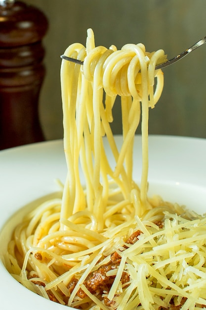 Vue latérale d'une fourchette avec des spaghettis autour