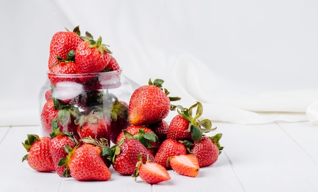 Vue latérale fraise dans un pot sur fond blanc