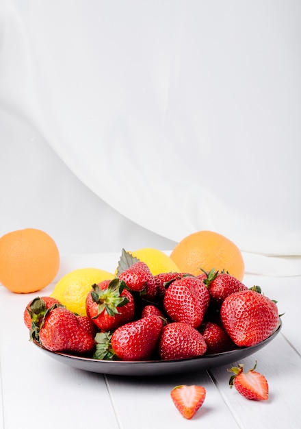 Vue latérale fraise fraîche au citron basilic et orange sur fond blanc