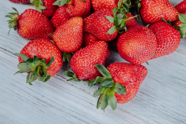 Vue latérale des fraises mûres fraîches sur bois blanc