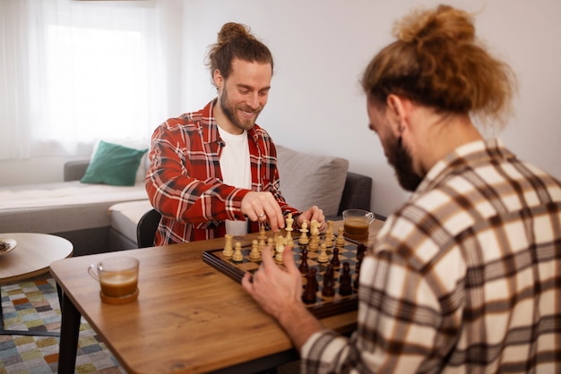 Photo gratuite vue latérale frères jouant aux échecs