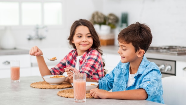 Vue latérale des frères et sœurs prenant son petit déjeuner