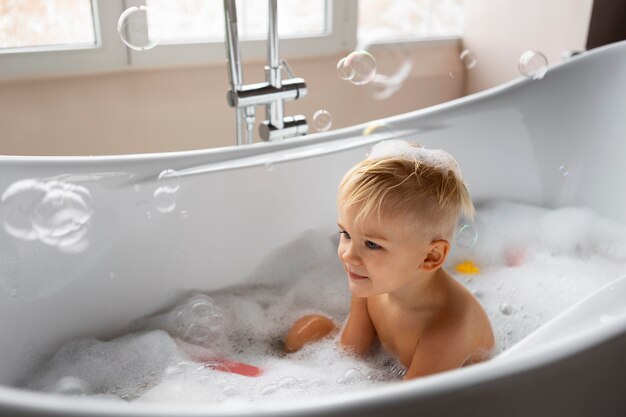 Vue latérale garçon jouant dans la baignoire