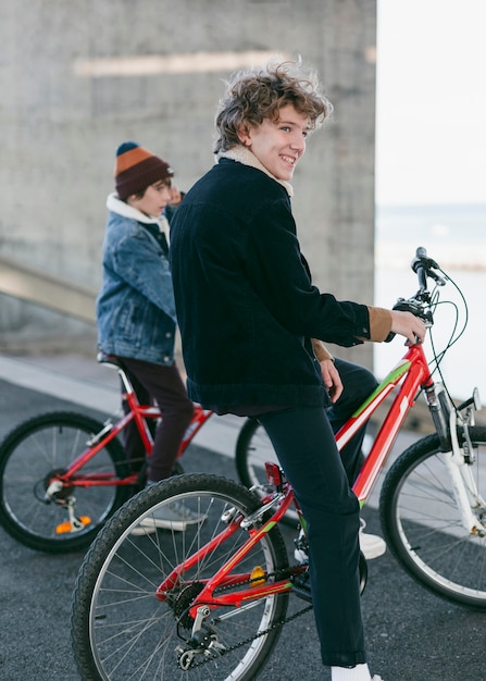 Vue latérale des garçons à l'extérieur dans la ville avec leurs vélos