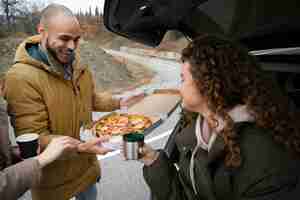 Photo gratuite vue latérale des gens avec une délicieuse pizza