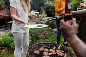Photo gratuite vue latérale des gens faisant un barbecue ensemble